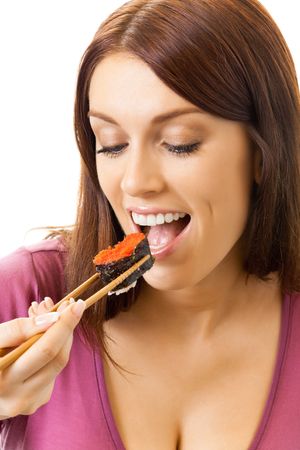 Young happy woman eating sushi roll by chopsticks, isolated on whiteの写真素材
