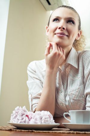 Young happy woman with plate of cakes at homeの写真素材