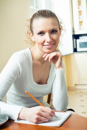 Young woman with notebook or organiser at homeの写真素材