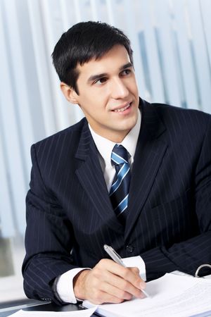 Successful businessman with documents at officeの写真素材