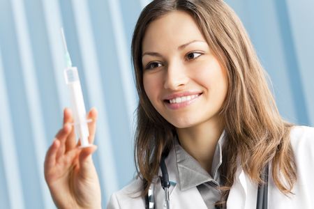 Happy female doctor with syringe at officeの写真素材