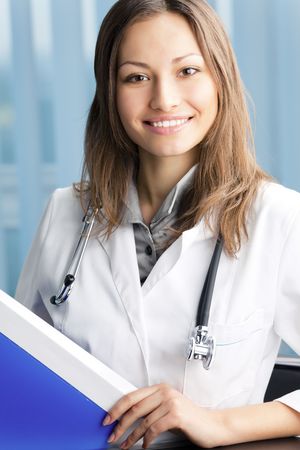 Happy doctor with blue folder at officeの写真素材
