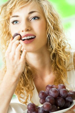 Young happy woman with plate of grapeの写真素材