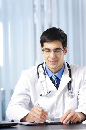 Portrait of writing doctor at officeの写真素材