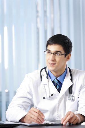 Portrait of writing doctor at officeの写真素材