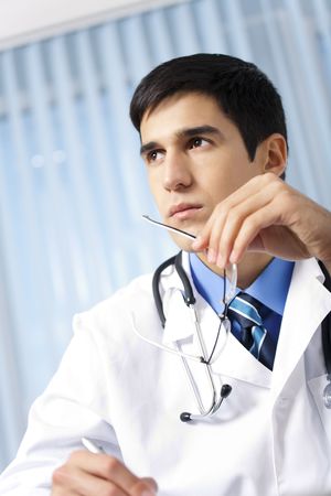 Portrait of writing doctor at officeの写真素材