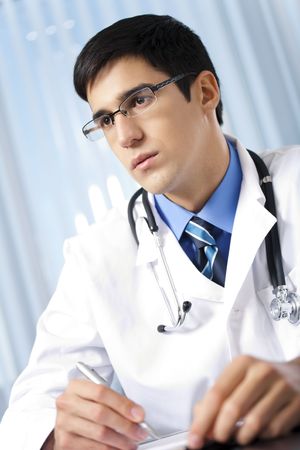 Portrait of writing doctor at officeの写真素材