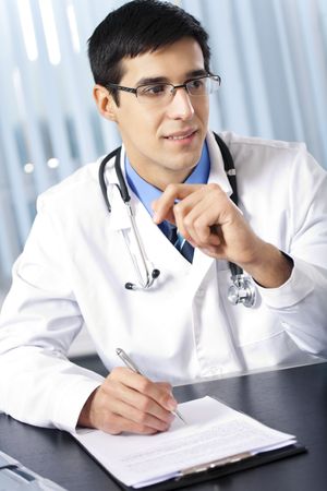 Portrait of writing doctor at officeの写真素材