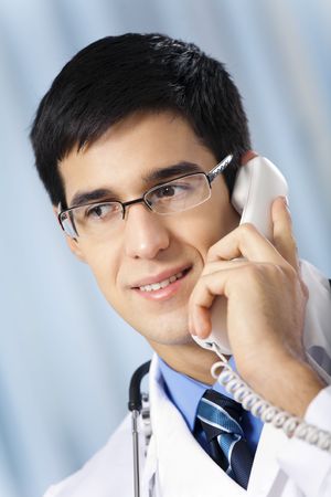 Successful doctor with phone, at workplaceの写真素材