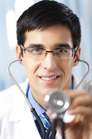 Doctor with stethoscope, at officeの写真素材