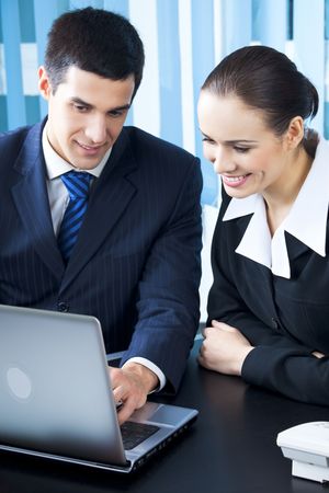 Two businesspeople working with laptop at officeの写真素材