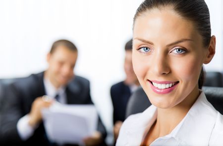 Portrait of successful businesswoman and colleagues on background, at officeの写真素材
