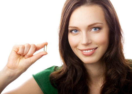 Portrait of woman showing Omega 3 fish oil capsule, isolated on white backgroundの写真素材