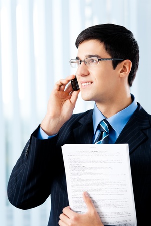 Happy smiling businessman showing document or contract, at officeの写真素材