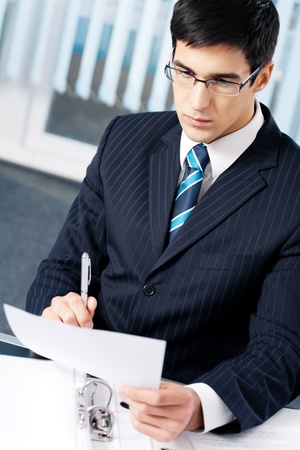 Portrait of reading businessman working at officeの写真素材