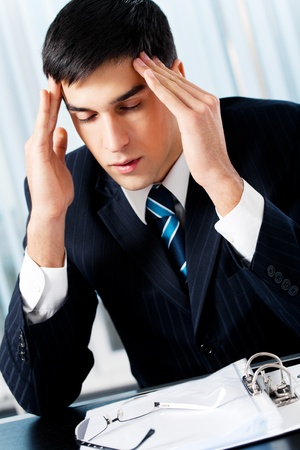 Thinking, tired or ill with headache businessman at officeの写真素材