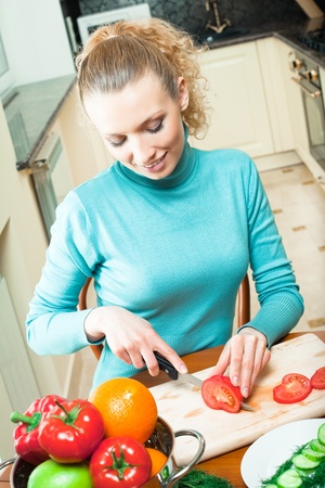 Portrait of happy smiling woman cooking with vegetables, at homeの写真素材