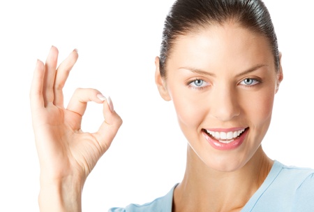 Portrait of happy smiling young woman with okay gesture, isolated on white backgroundの写真素材