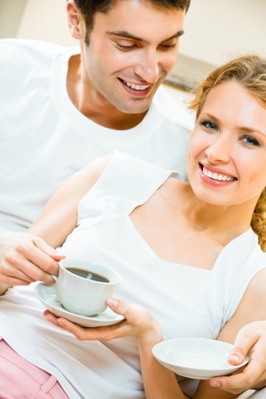 Young happy amorous couple drinking coffee together at homeの写真素材