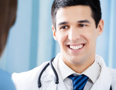 Happy smiling doctor and young female patient at officeの写真素材
