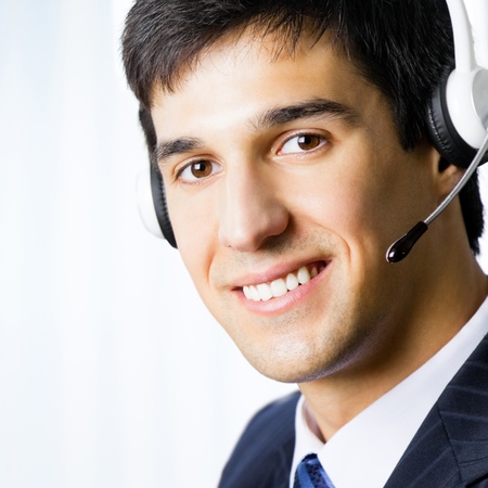 Portrait of happy smiling customer support phone operator in headset at officeの写真素材
