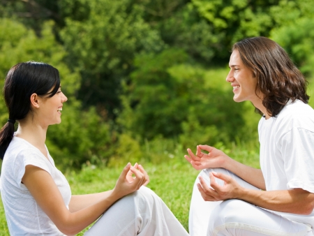 Young happy attractive couple meditating together, outdoorsの写真素材