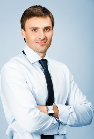 Portrait of happy smiling young business man, over blue backgroundの写真素材