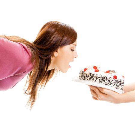 Cheerful woman eating pie, isolated over white backgroundの写真素材