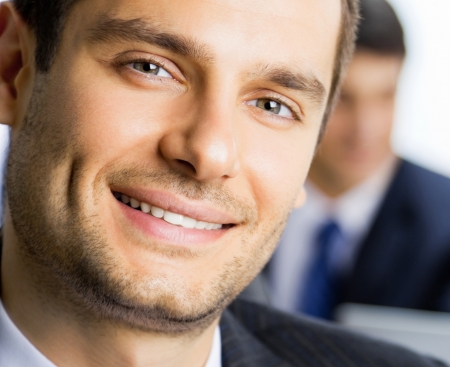 Portrait of happy smiling young businessman at officeの写真素材