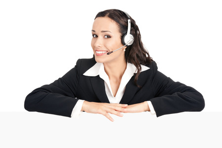Happy smiling young customer support phone operator in headset showing blank signboard, isolated over white backgroundの写真素材