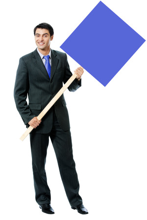 Happy smiling young businessman in blue tie, showing blank signboard with copyspace area for text or slogan, isolated against white backgroundの写真素材