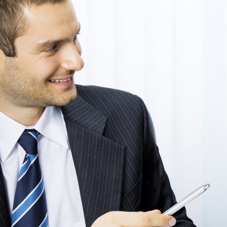Young businessman, giving pen for signing document, at officeの写真素材