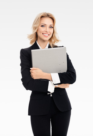 Portrait of young happy smiling businesswoman with grey folder, with blank copyspace area for slogan or text, on grey backgroundの写真素材