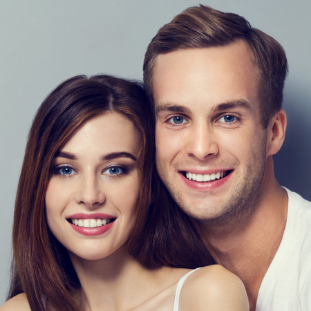 Portrait of young couple, looking at you. Caucasian models - love, relationship, dating, happy lovers, concept shot, against grey.の写真素材