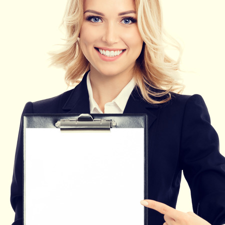 Smiling young businesswoman showing blank clipboard, with copyspace area for text or sloganの写真素材