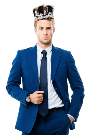 I am business king! Portrait of young serious businessman in crown, isolated on white background. Leadership and business success concept.の写真素材