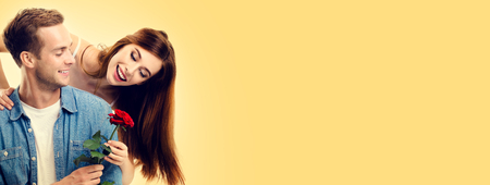 Portrait of happy hugging couple with flower, close to each other, with smile. Love, relationship, dating, flirting, lovers, romantic concept. Copy space for some text, or slogan.の写真素材