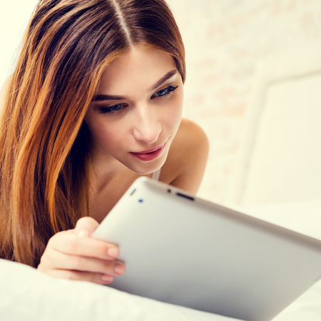 Picture of young woman using tablet pc, at homeの写真素材
