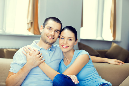 Portrait photo of young happy smiling couple at homeの写真素材