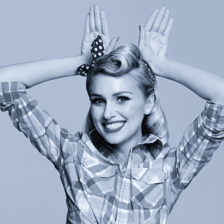 Portrait photo of beautiful young happy smiling woman, dressed in pin-up style. Caucasian girl model posing in retro fashion and vintage concept. Black and white. Square composition image.の写真素材