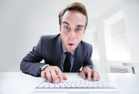 Shocked or surprised businessman in black confident style suit, working with computer at office. Success in business, job and education concept.の写真素材