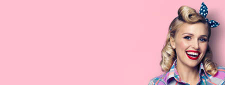Portrait image - amazed pin up girl. Excited happy woman. Retro fashion and vintage concept. Pastel pink color background. Copy space for some slogan or text.の写真素材