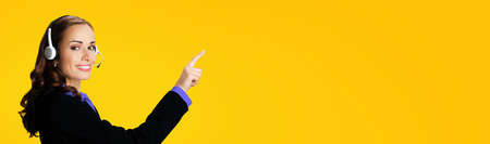 Call Center Service. Customer support or sales agent. Businesswoman or caller or phone operator in black suit and violet blouse showing pointing at copy space or imaginary. Help answering, consulting.の写真素材