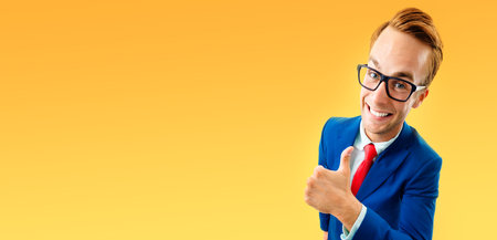 Portrait of funny businessman in glasses, blue confident suit and red tie, showing thumbs up...