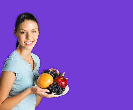 Portrait image of young happy smiling attractive woman in blue casual smart clothing, with plate of...