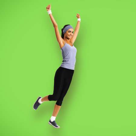 Full body of happy woman jumping or doing fitness exercise, isolated on green color background. Fit...