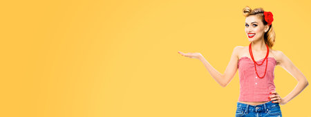 Amazed happy woman holding, giving something. Excited girl in pin up, showing product or copy space...