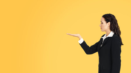 Profile side of beautiful businesswoman showing something or copy spase for product. Brunette woman...