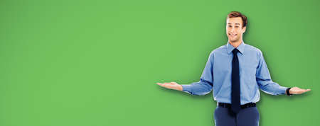 Comparison concept - confident businessman showing, holding or giving something on both flat hands for similar choice, over green color background. Copy space area for text.の写真素材