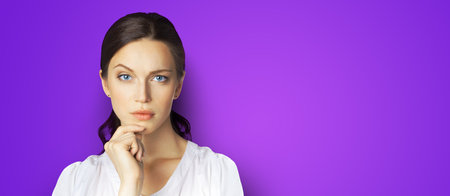 Portrait of puzzled, shocked, astonished businesswoman in white clothing, isolated over violet purple color background with copy space area. Confident business woman at studio. Wide banner compositionの写真素材